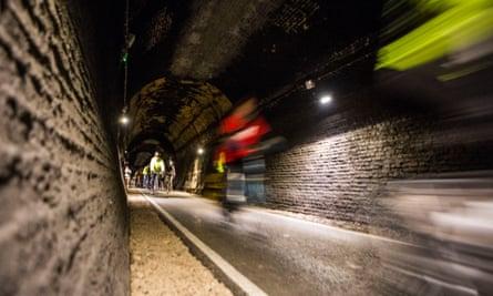 Cyclists riding through the restored Devonshire Tunnel which is part of the Two Tunnels Greenway.